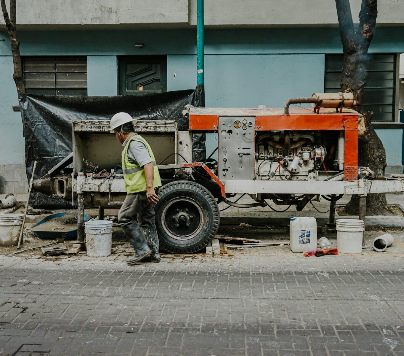 Photo by Estefania Ruiz a man in a hard hat is working on a truck