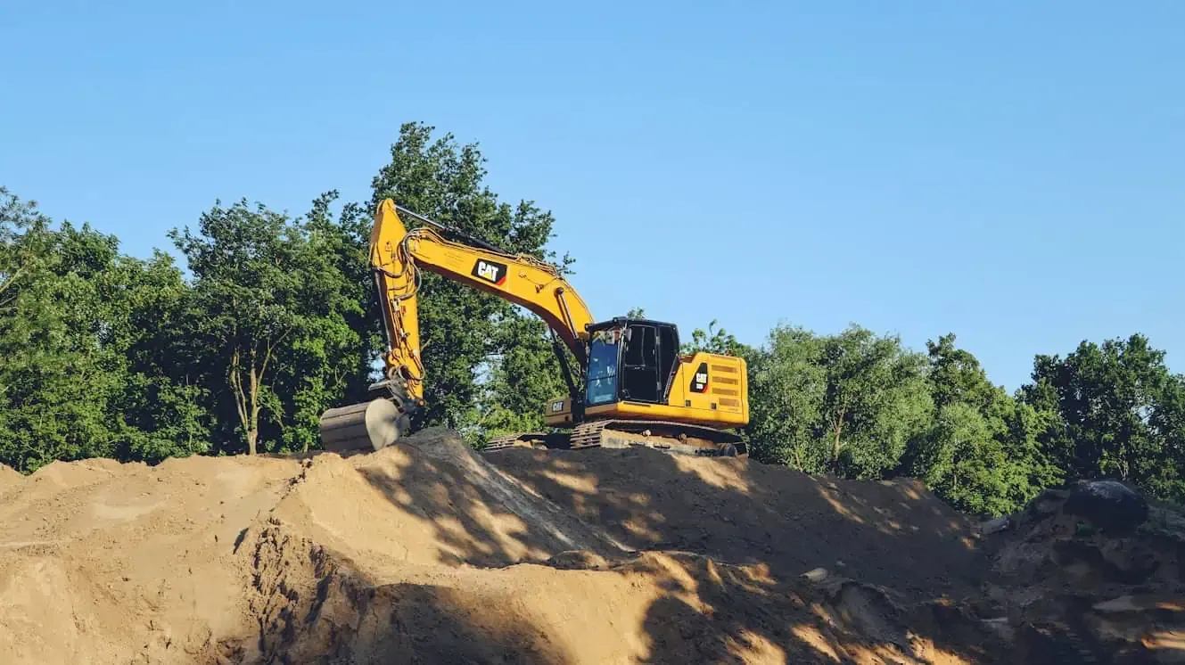 Excavator working at a construction site supported by TAINEQ heavy equipment rental services