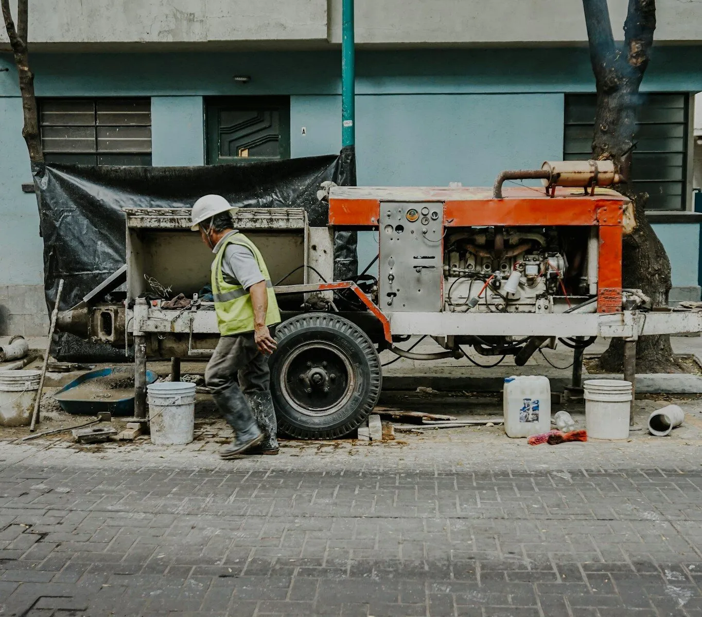 Photo by Estefania Ruiz a man in a hard hat is working on a truck