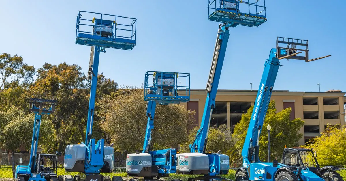 pexels-photo-16105409-16105409 Outdoor scene with multiple blue aerial lifts and heavy machinery in a sunny industrial area.