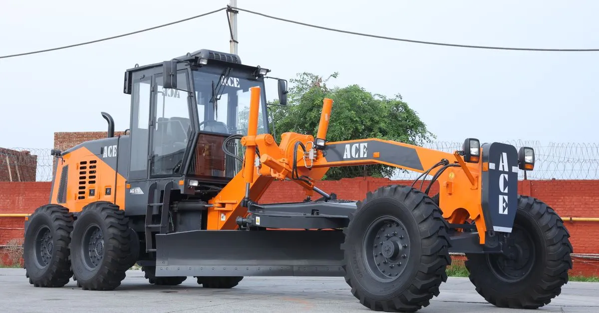 Orange ACE motor grader at road construction site in India, clear day.